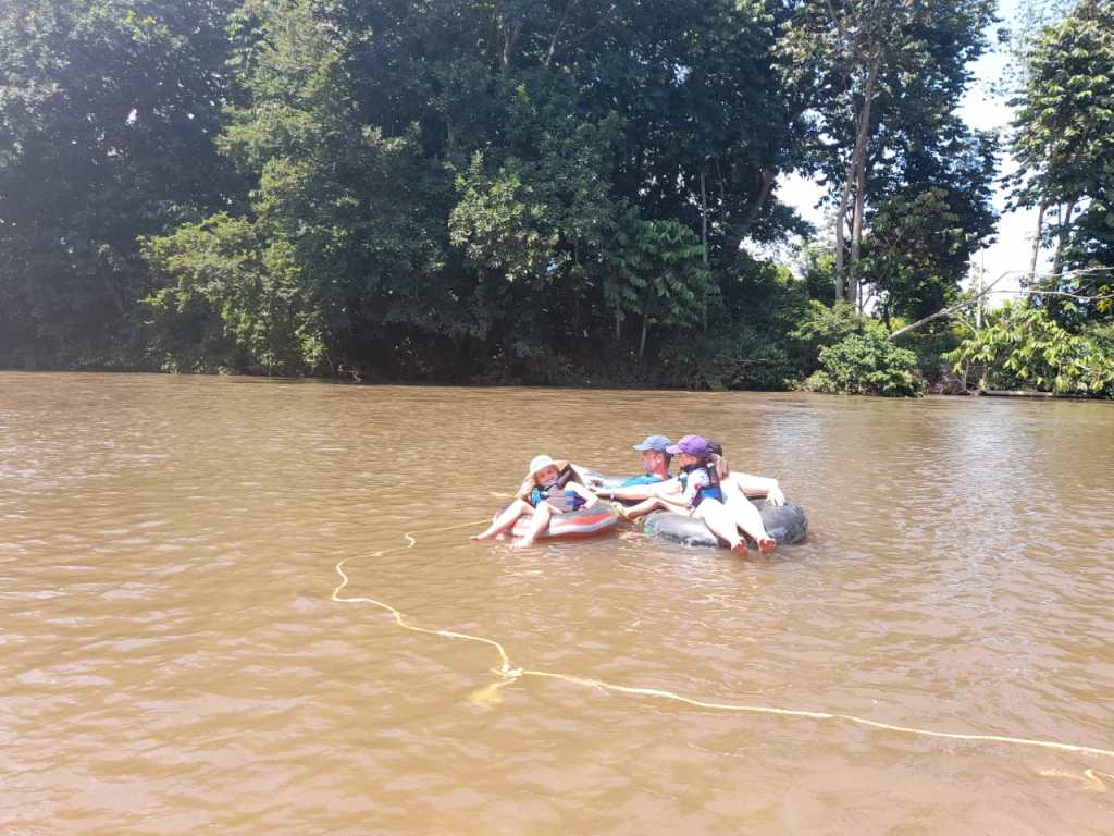 Family floating down dirty river in tubes