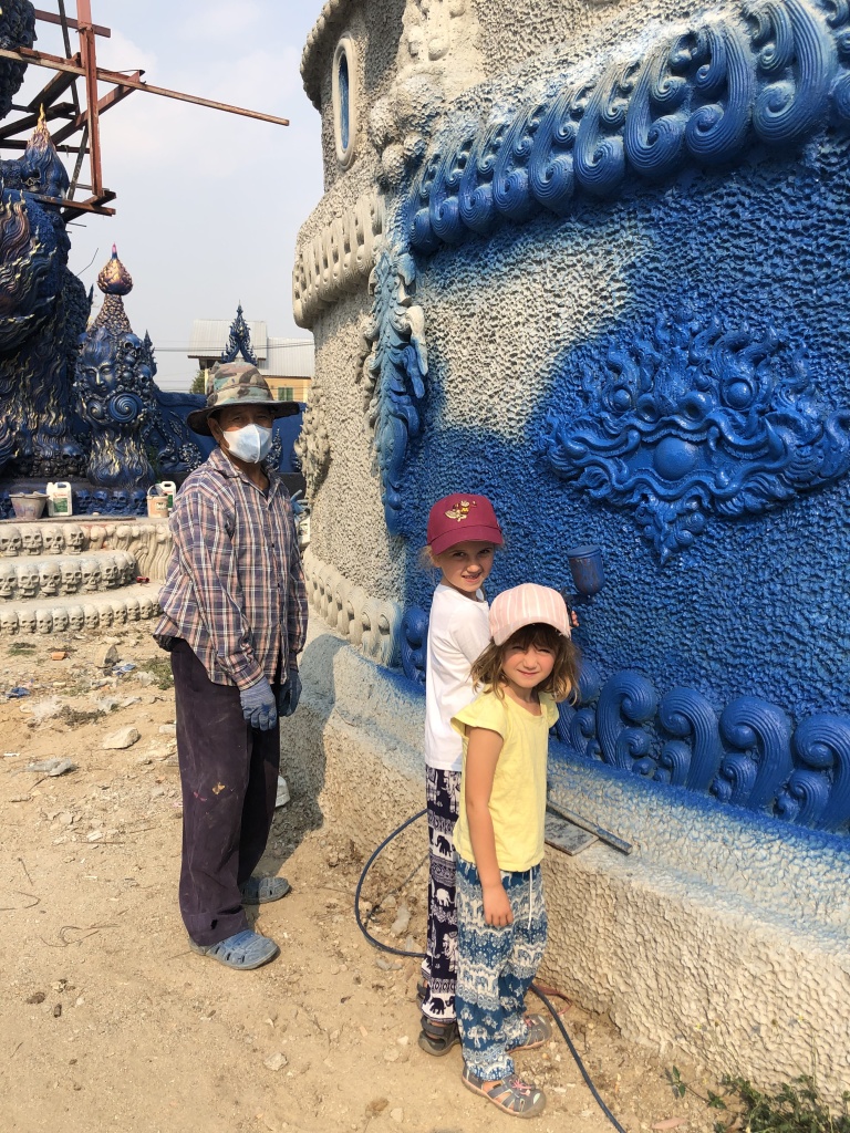 Children spray painting temple wall blue